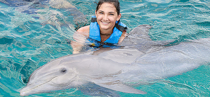 woman smiling with a dolphin