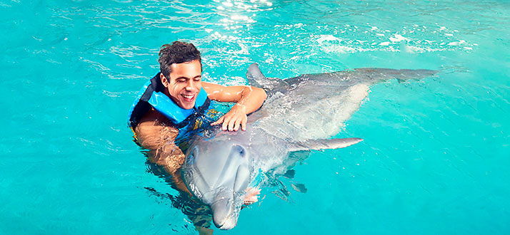 guy smiling with a dolphin in punta cana